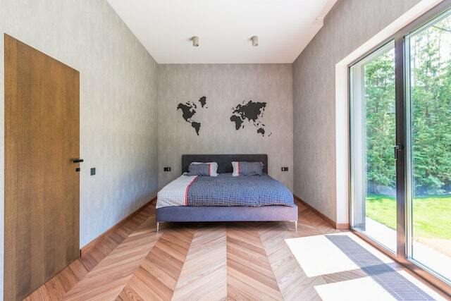 A minimalist bedroom with sliding doors leading to a garden.