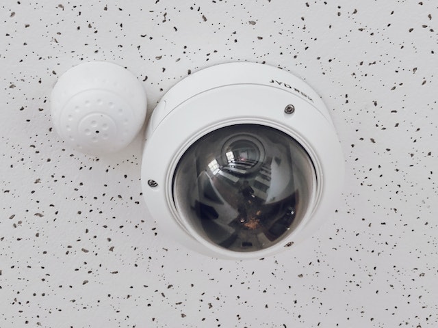 CCTV camera installed in a room with white ceiling.