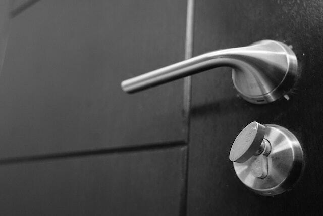 Close-up photo of gray stainless steel door lever and lock.