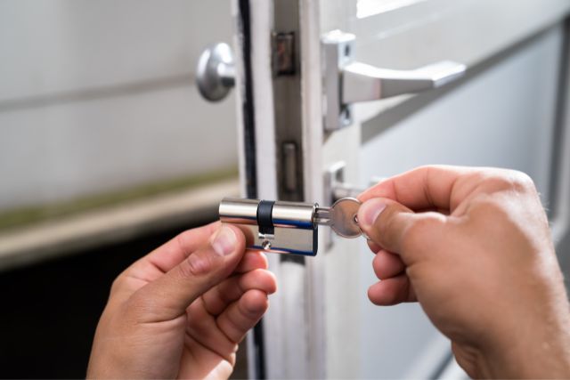 A locksmith changing the cylinder of a door lock.
