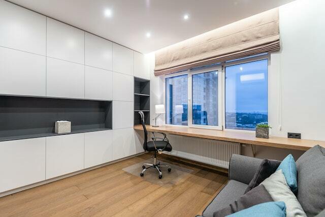 An empty office with big white windows.