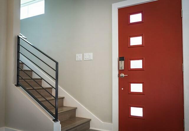 A red front door beside a staircase.