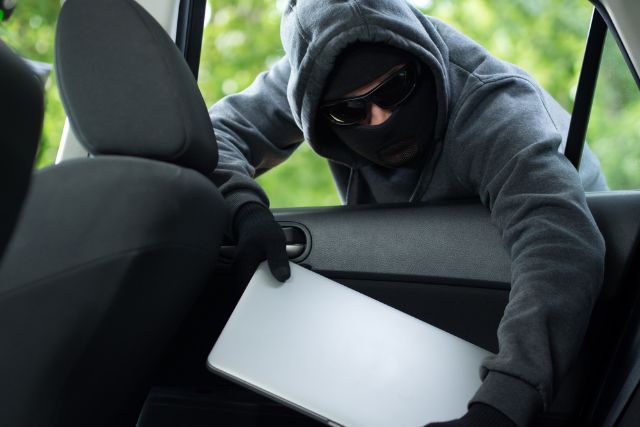 A laptop being stolen from a parked car.