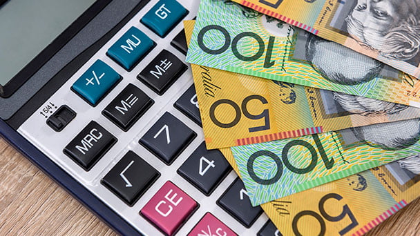 Australian bank notes laying on top of a calculator