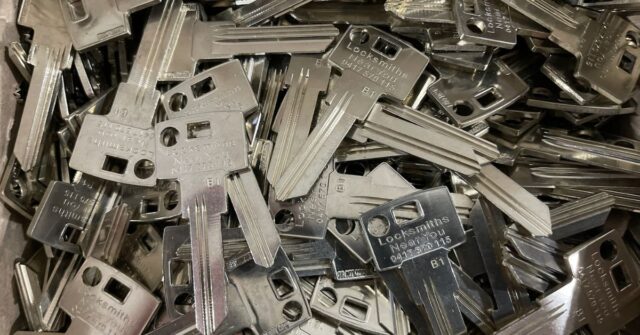 Buk lot of restricted keys with Locksmiths Near You name and phone number printed on them.