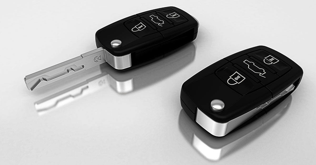 Two matching electronic car keys, one with key extended and the other with the key retracted in the handle.