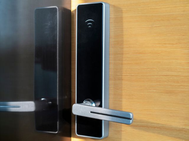 Large smart lock with black mirror finish showing a Wi-Fi signal and handle.
