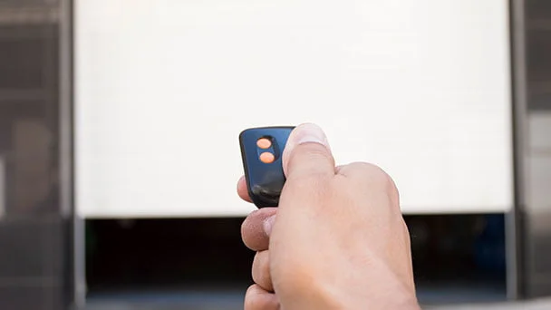 Person using a garage remote to open the garage door.