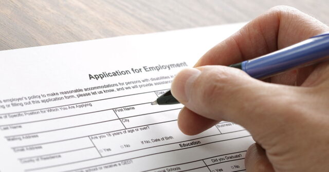Person completing application for employment with a pen
