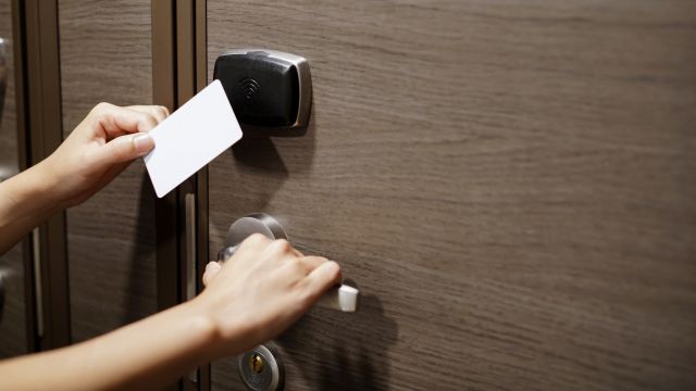 Person holding white card to sensor so that door handle lock can be opened.