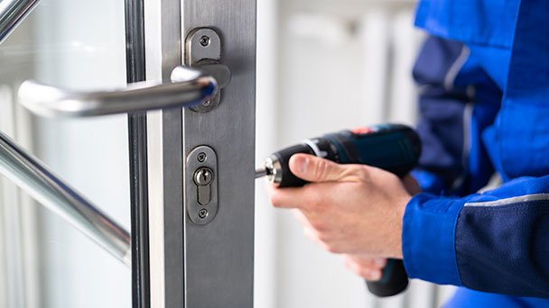 Locksmith installing new lock on internal door.