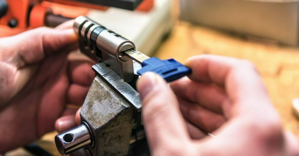 Locksmith cutting a key that can control multiple lock barrels.