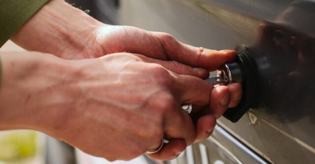 Man trying to remove the stuck keys from his car lock.